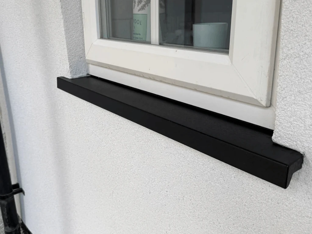 Repaired black uPVC window sill beneath a white frame
